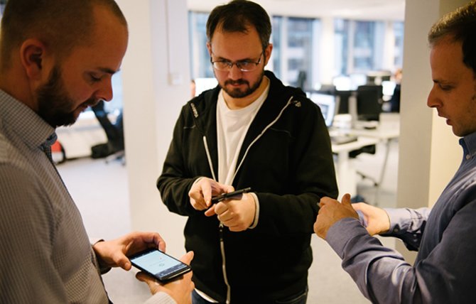 Her tester tre Carismar-ansatte muligheten for at den injiserte chipen i håndenkan åpne smarttelefonene deres.