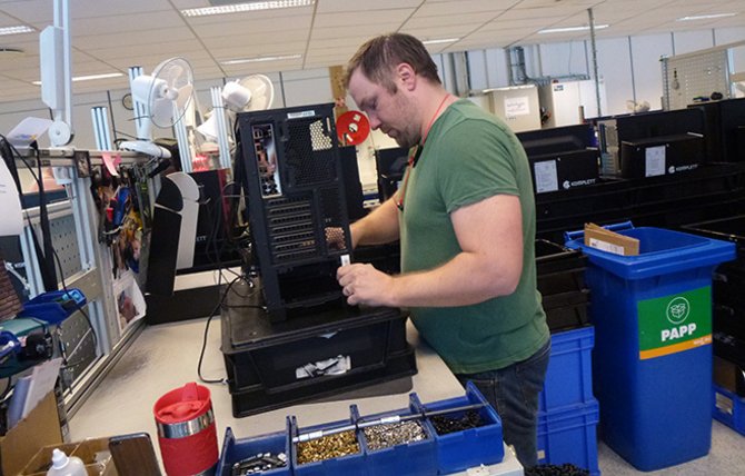 André Olsen er klar for å montere en ny PC. Bak ham, på hovedsporet, ligger det i hver av de svarte boksene deler som skal bli en komplett PC.