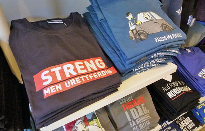 T-skjortene med trykket «Streng men urettferdig» på brystet er vistnok blitt en slager blant den norske lærerstanden. «Pålegg fra politiet» er hentet fra Absurdgalleriet.